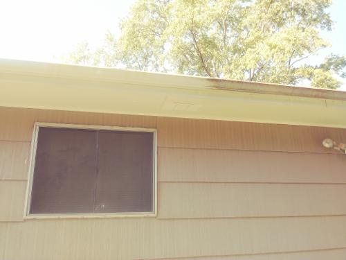 A section of gutter before and after cleaning.